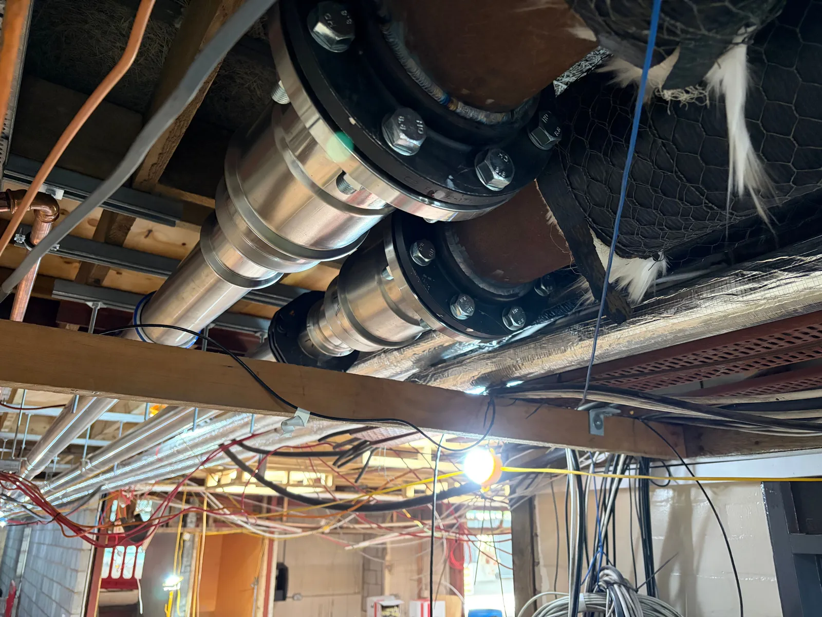 Twin stainless steel pipe runs with flanged connections on a commercial fit-out